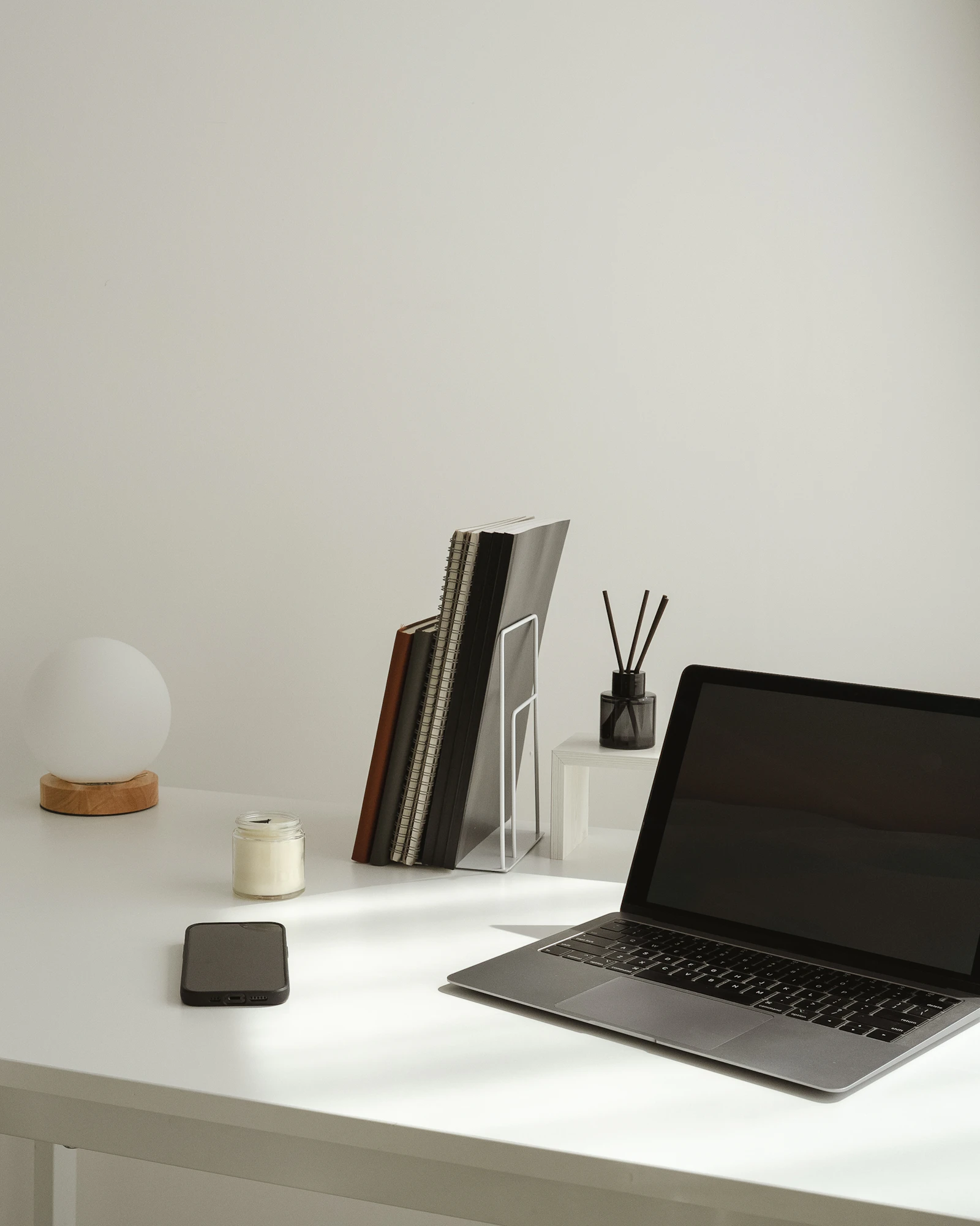 Un poste de travail épuré avec un ordinateur portable et quelques accessoires, dans des tons neutres