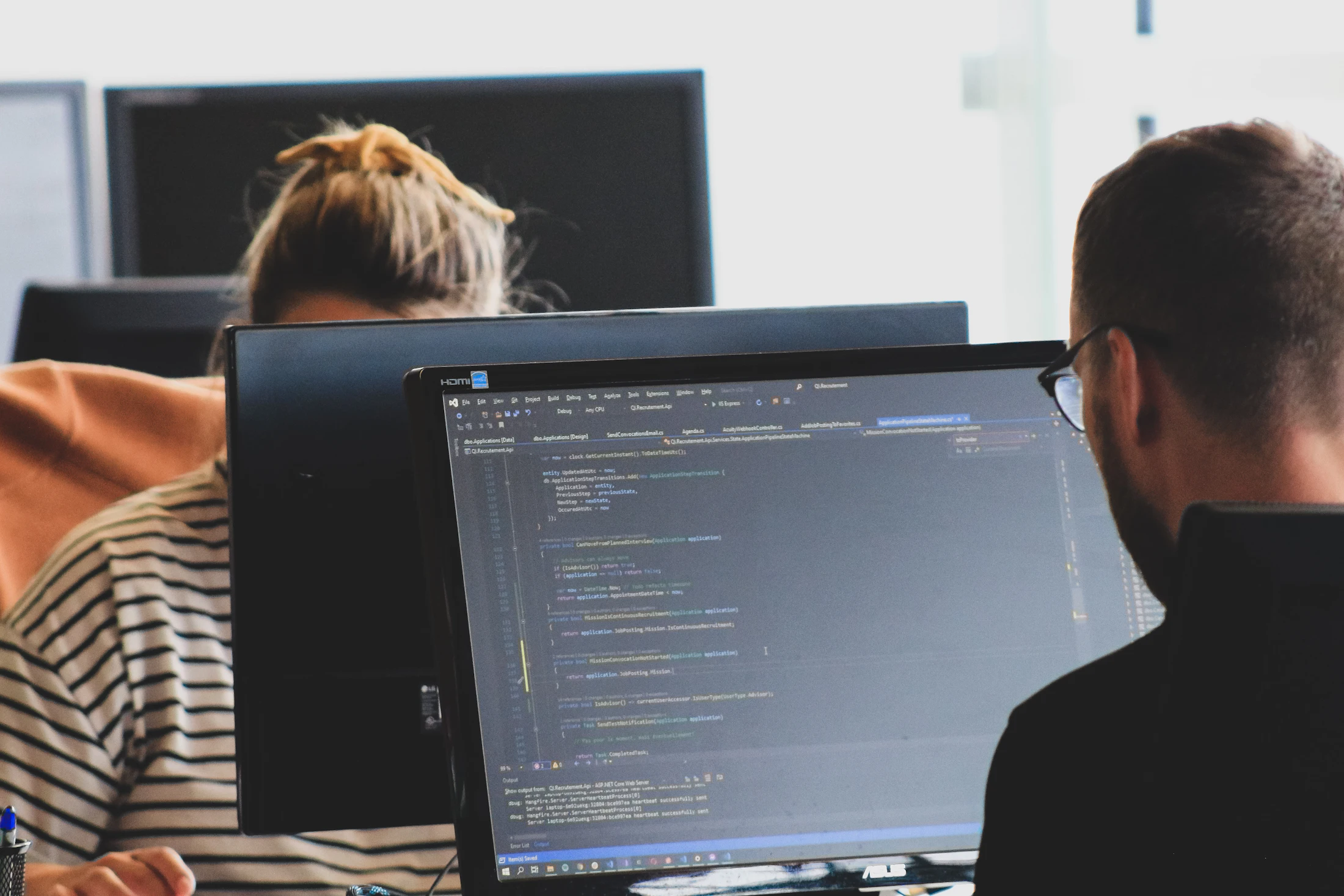 Deux développeurs relisant du code ensemble sur un ordinateur portable